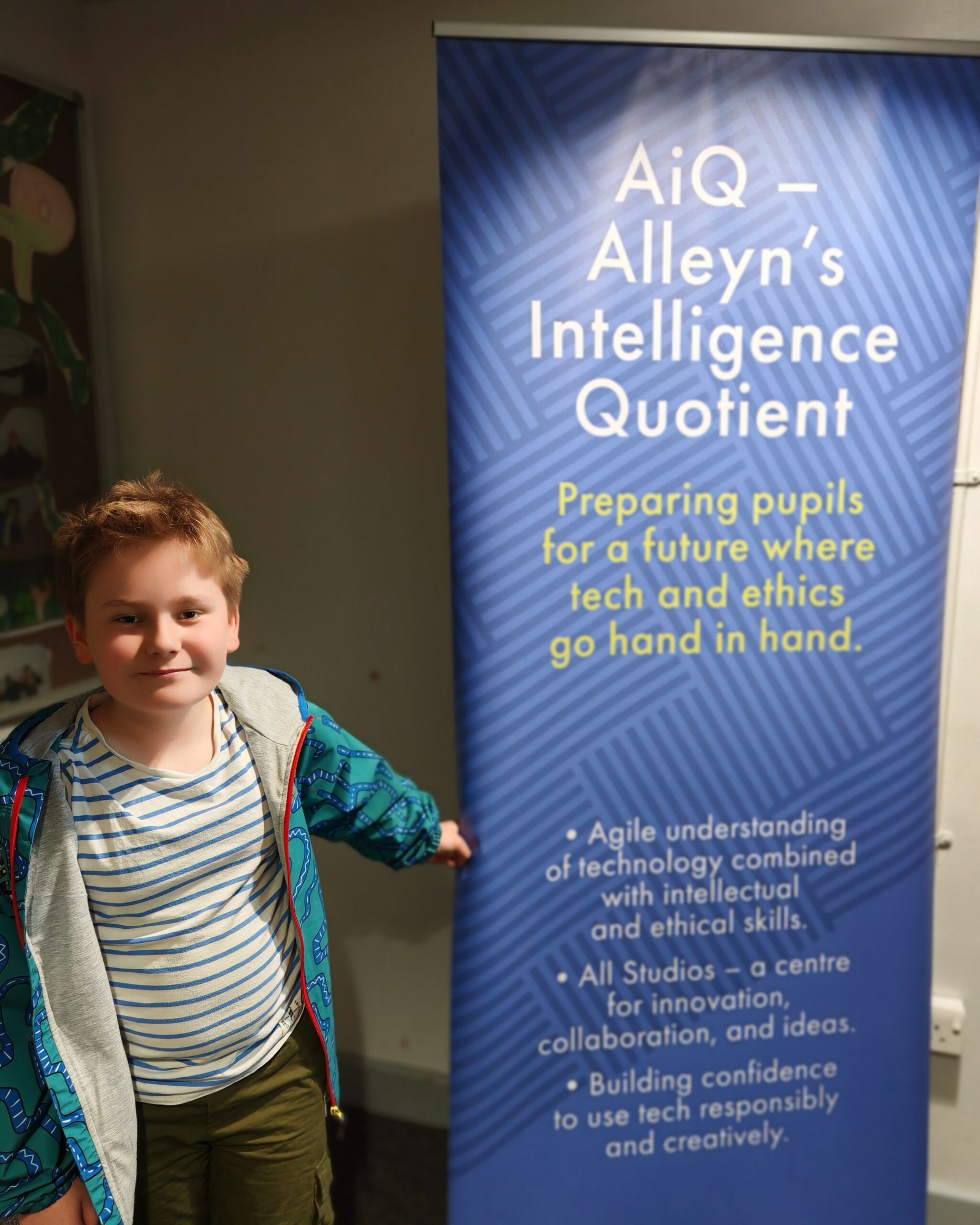Young white boy standing right next to a school post about AiQ, the Alleyn's Intelligence Quotient that is part of the curriculum Young white boy standing right next to a school post about AiQ, the Alleyn's Intelligence Quotient that is part of the curriculum