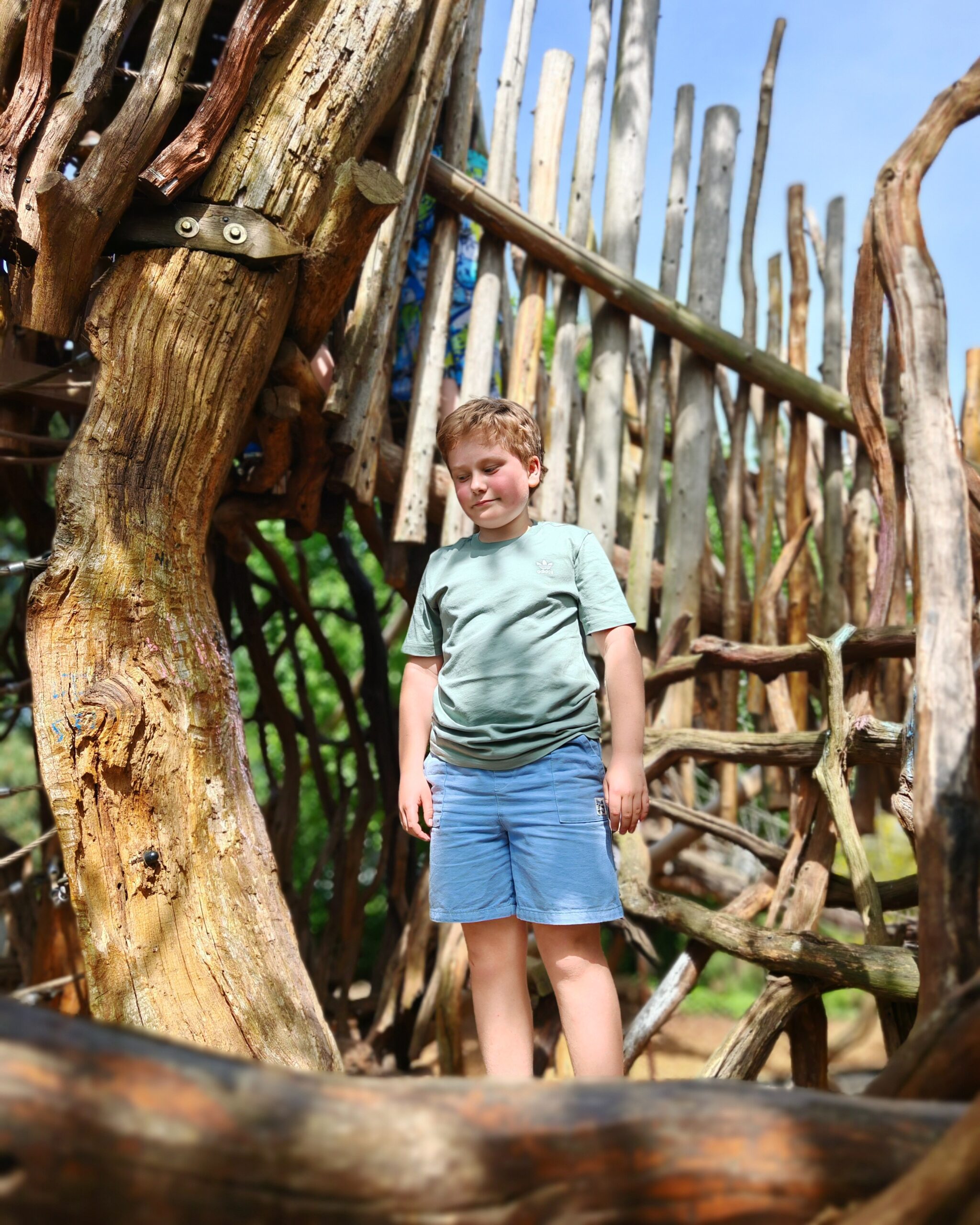 White little boy with a green tee-shirt and a blue short playing at the Tumbling Bay Playground in East London