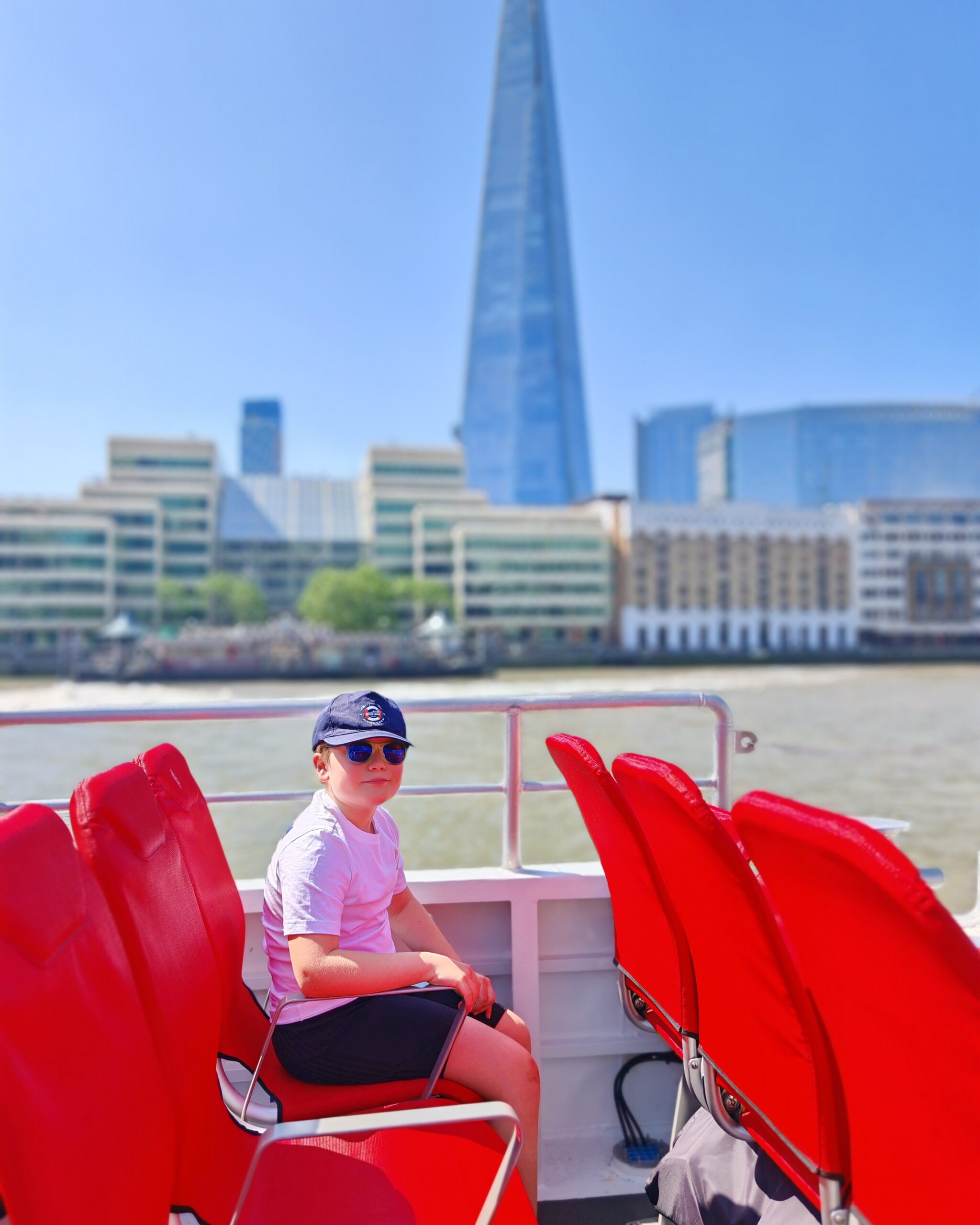 Little white boy on board of a Tower of London Review tour with the Shard in the background Little white boy on board of a Tower of London Review tour with the Shard in the background