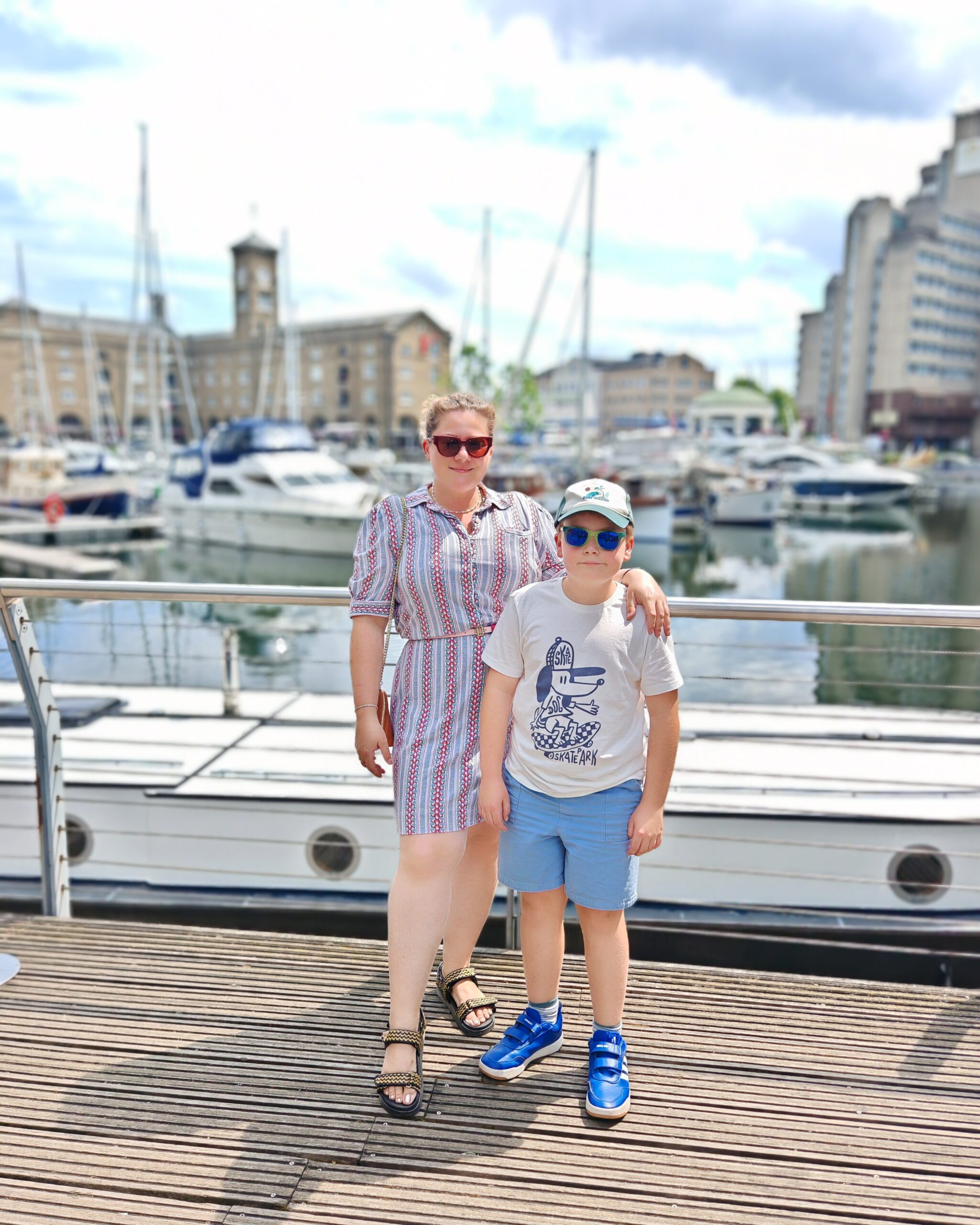 White woman and white little boy standing near boats at St Katharine Docks, the London marina near Tower Bridge White woman and white little boy standing near boats at St Katharine Docks, the London marina near Tower Bridge