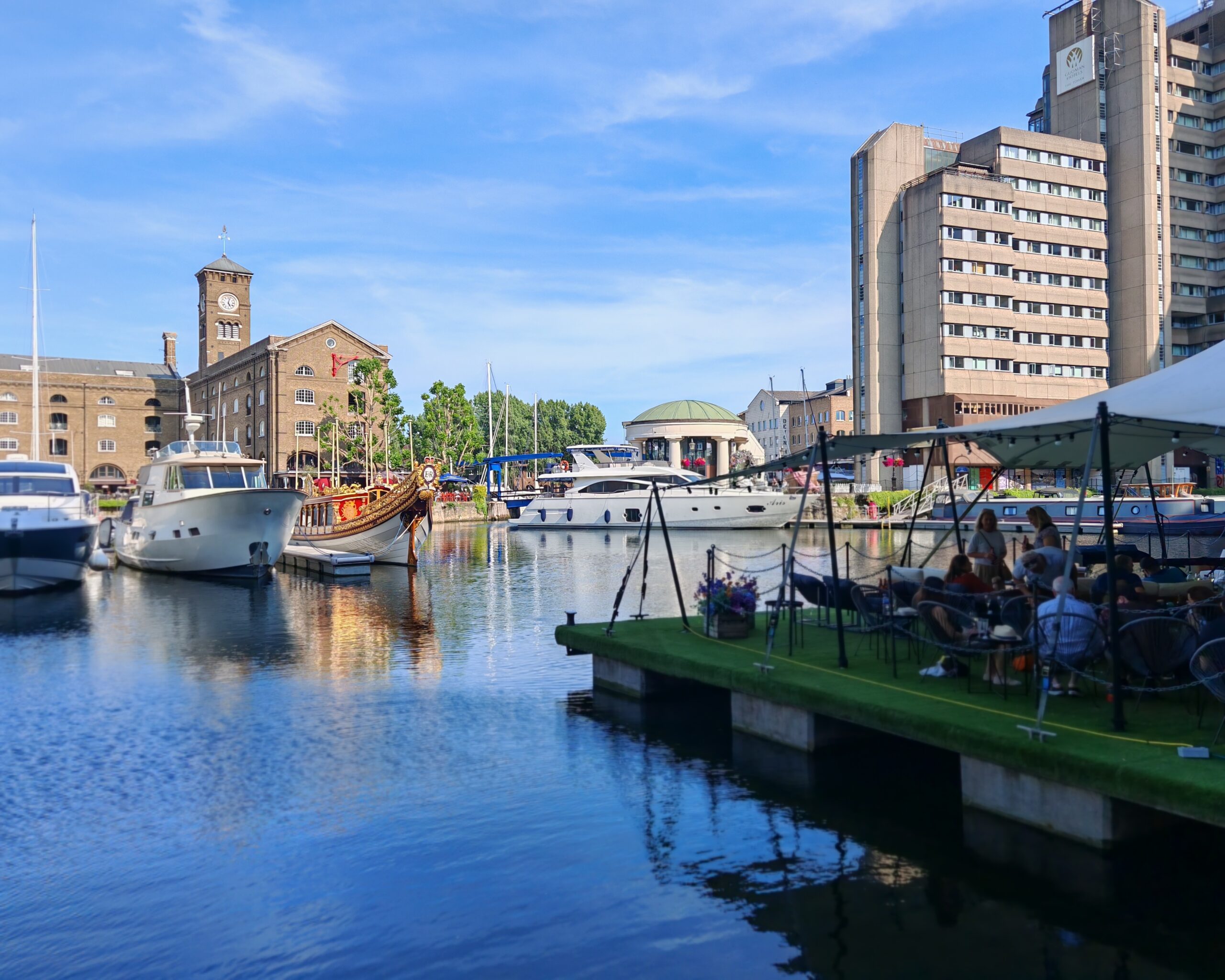 Floating pontoon at St Katharine Docks, overlooking the marina while people listen to jazz music.