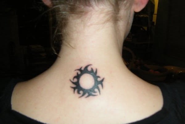close up of a tribal sun tattoo on the base of the neck of a white young lady. She's wearing a black top and has very pale skin close up of a tribal sun tattoo on the base of the neck of a white young lady. She's wearing a black top and has very pale skin