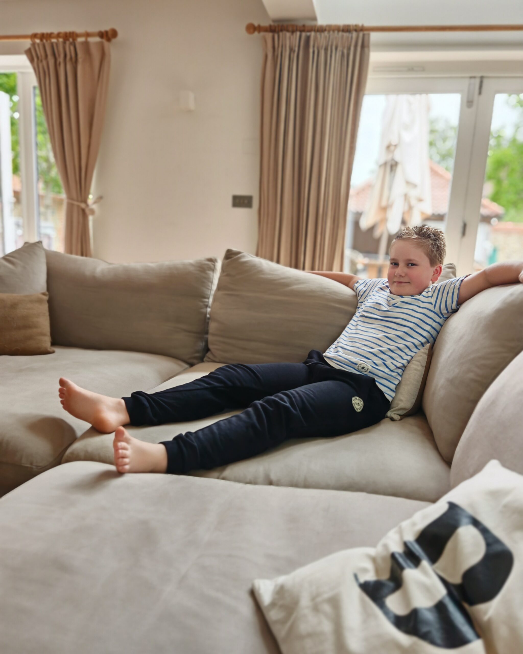 White little boy sitting on the sofa at Manor Farm Barns in Brancaster, a Barefoot Retreats Luxury accommodation White little boy sitting on the sofa at Manor Farm Barns in Brancaster, a Barefoot Retreats Luxury accommodation