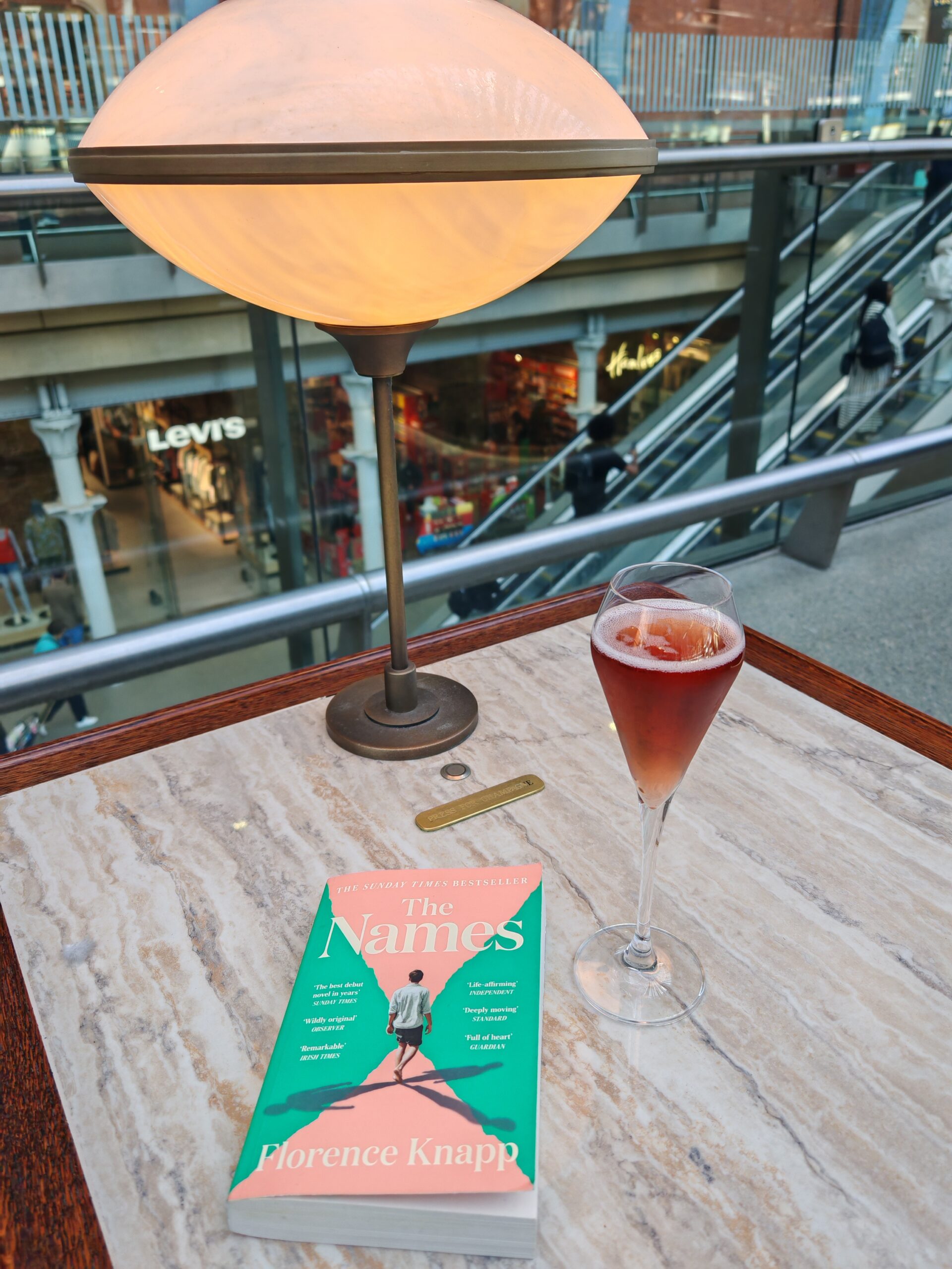 Flat lay of a glass of Kir Royale and a book at Searcy's Champagne bar at St Pancras International Flat lay of a glass of Kir Royale and a book at Searcy's Champagne bar at St Pancras International