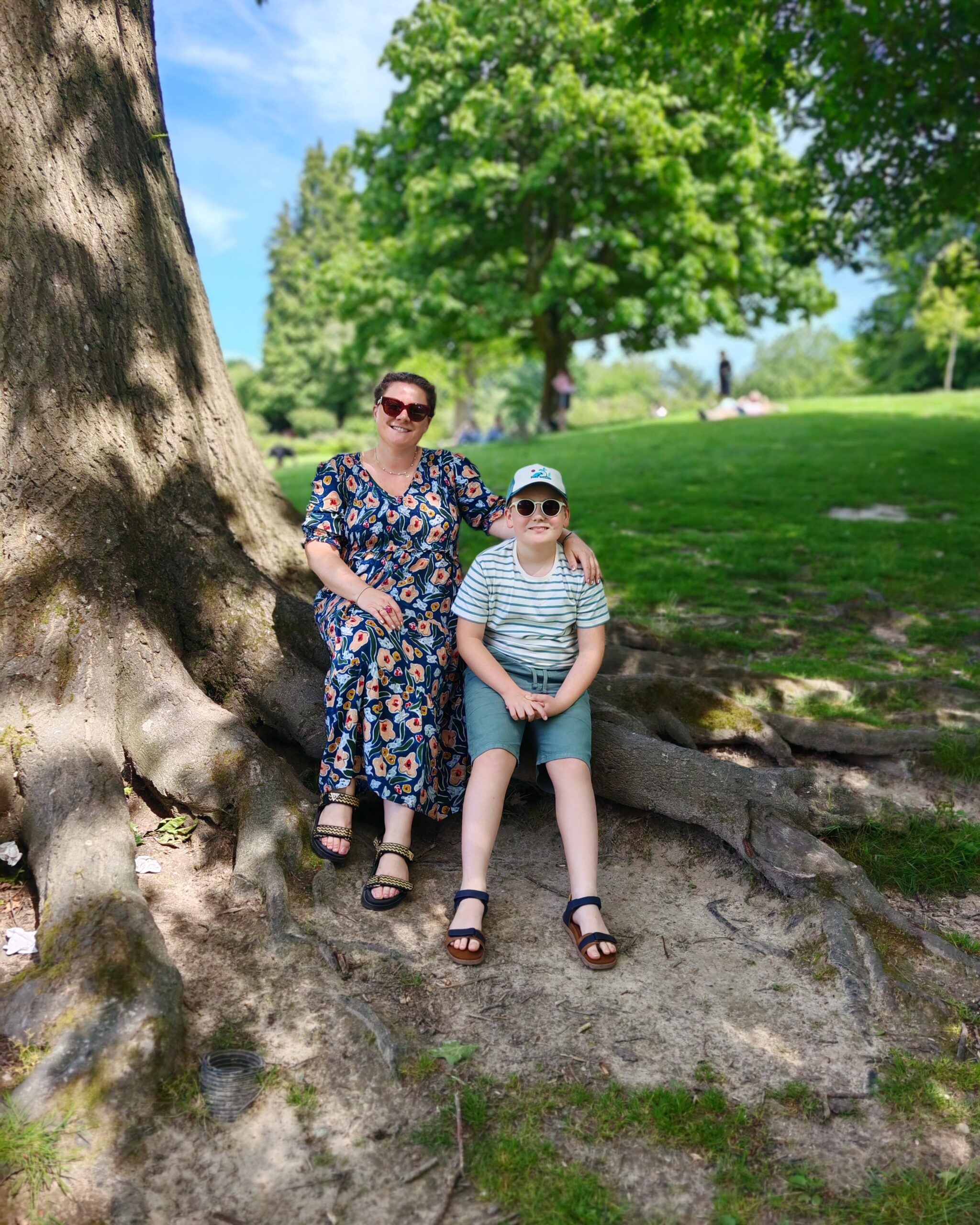 Little white boy with his mum in a green dress both sitting on the branch of a tree at Calverley Park in Royal Tunbridge Wells Little white boy with his mum in a green dress both sitting on the branch of a tree at Calverley Park in Royal Tunbridge Wells