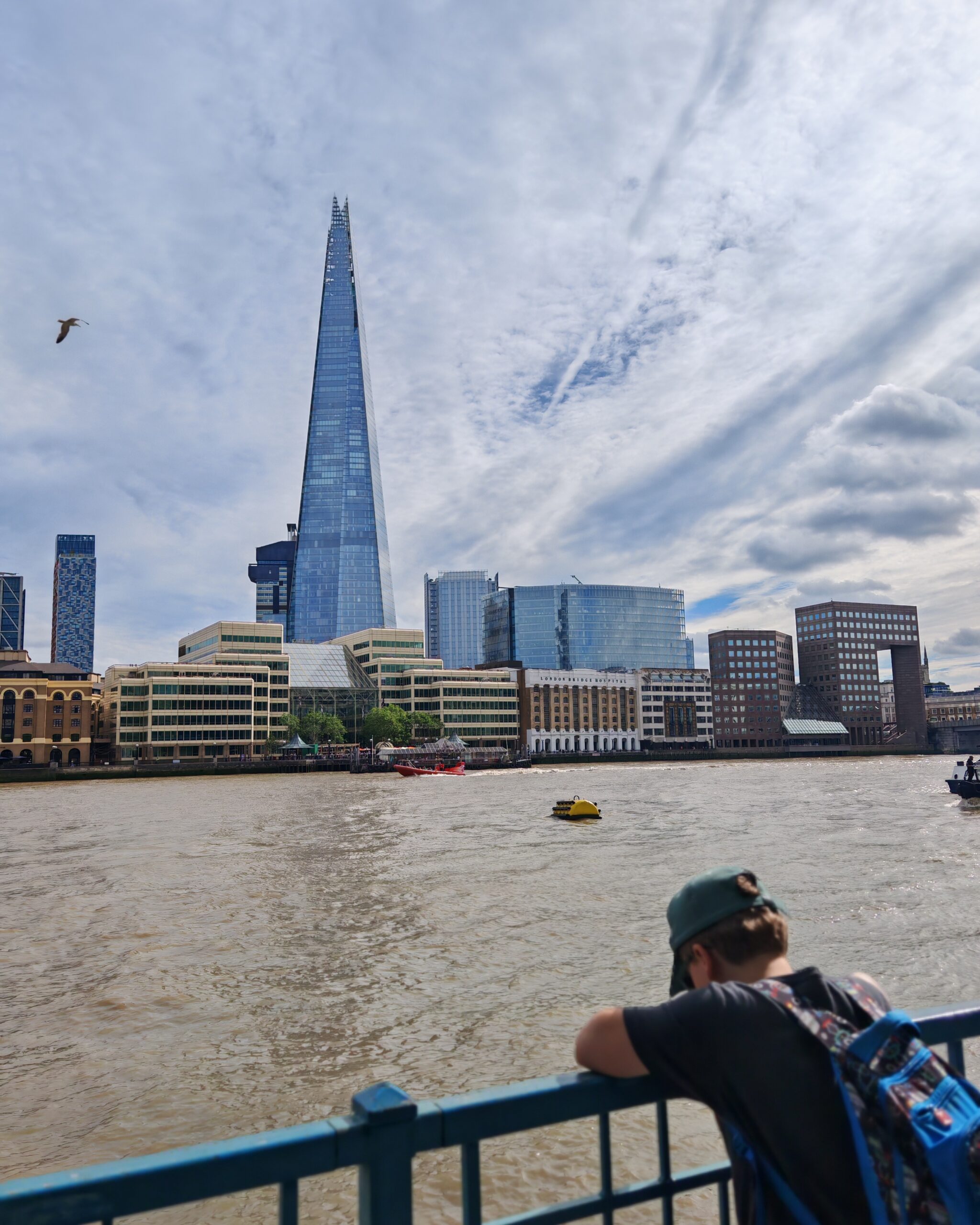 White little boy observing the Shard London from the other side of the River Thames White little boy observing the Shard London from the other side of the River Thames