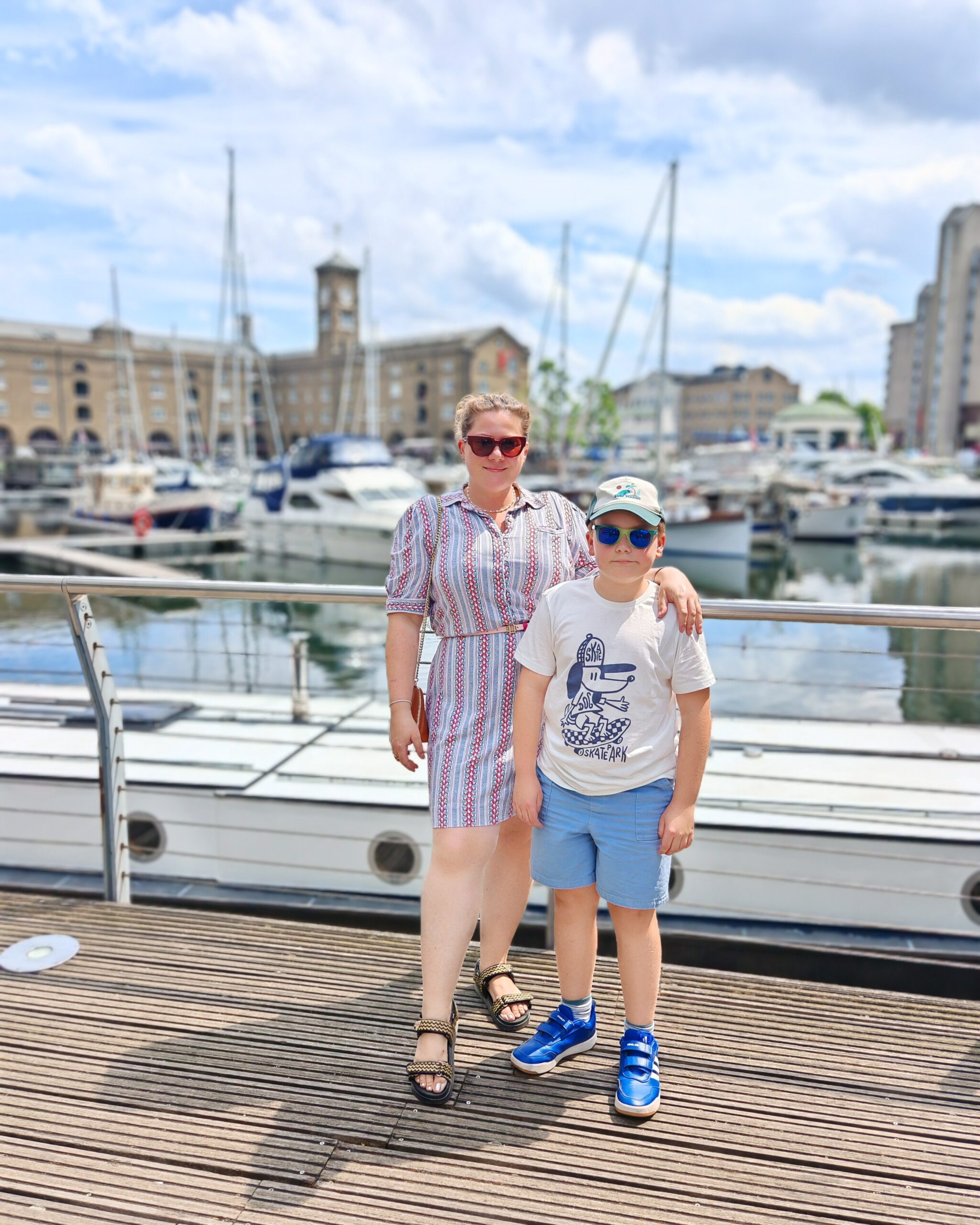 White woman in a vintage dress with her son on the London marina at St Katharine Docks White woman in a vintage dress with her son on the London marina at St Katharine Docks