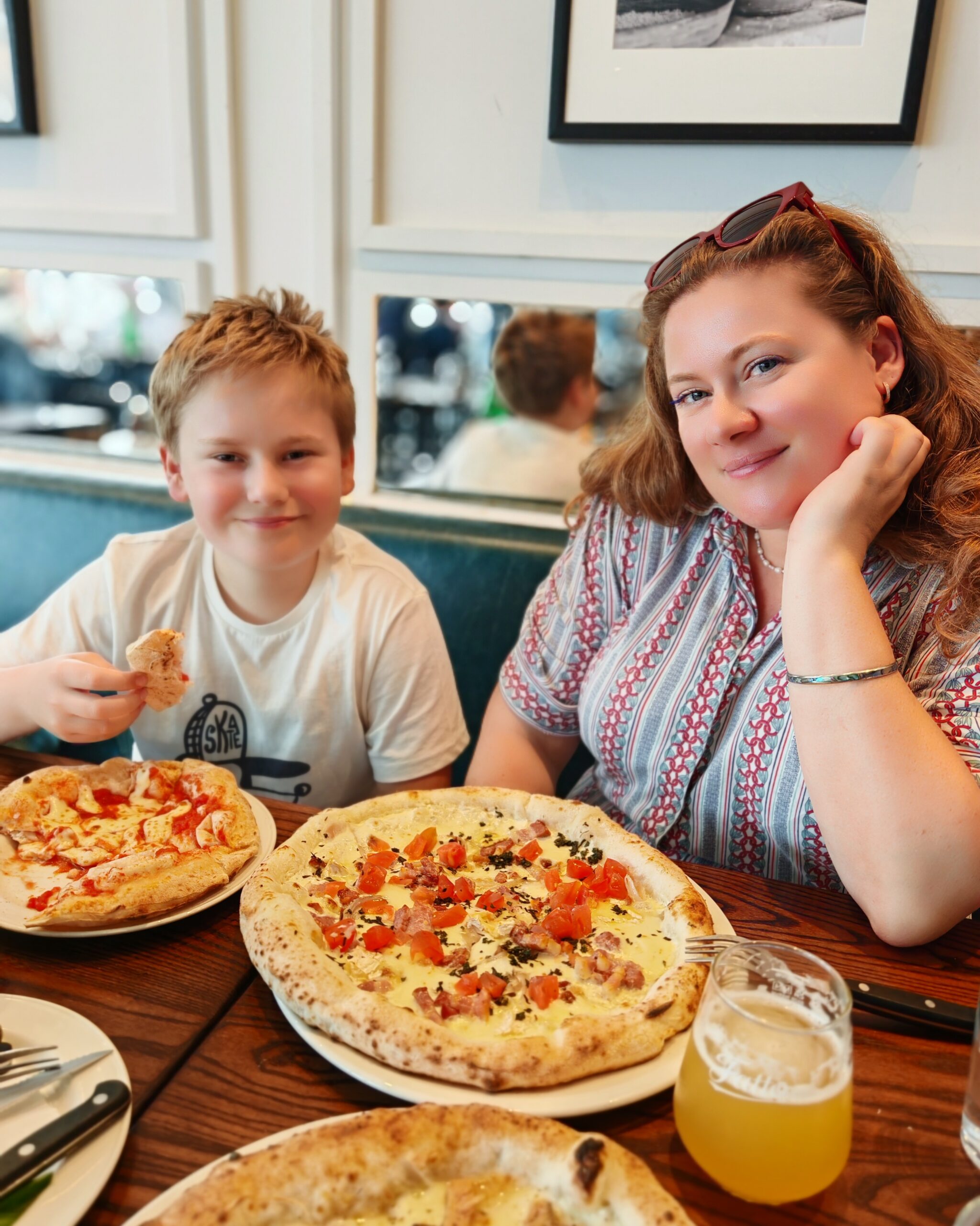 White little boy and his mum eating pizza at Fatto a Mano at St Katharine Docks Marina in London White little boy and his mum eating pizza at Fatto a Mano at St Katharine Docks Marina in London