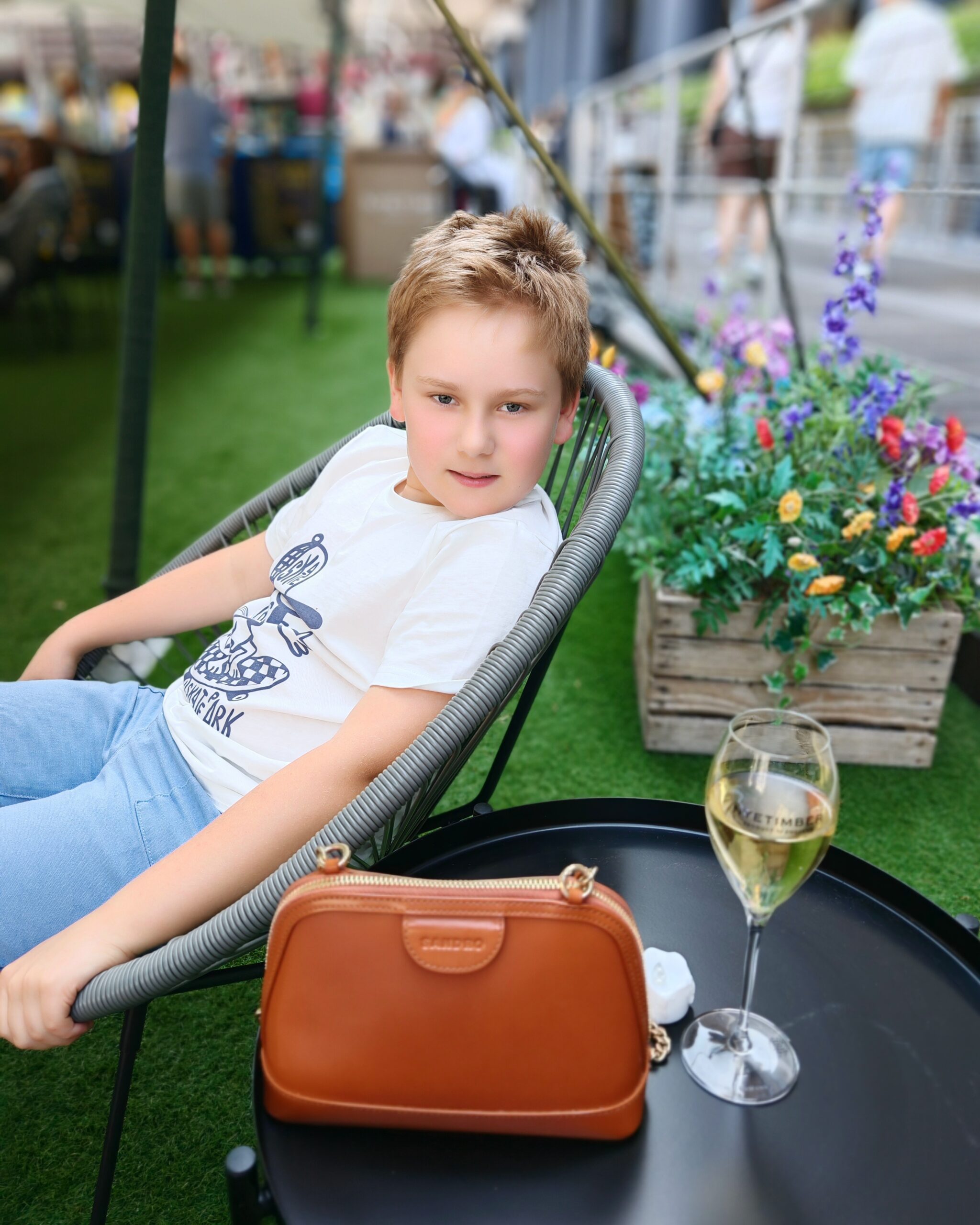 White little sitting on the pontoon at St Katharine Docks near his mum's handbag and a glass of champagne White little sitting on the pontoon at St Katharine Docks near his mum's handbag and a glass of champagne