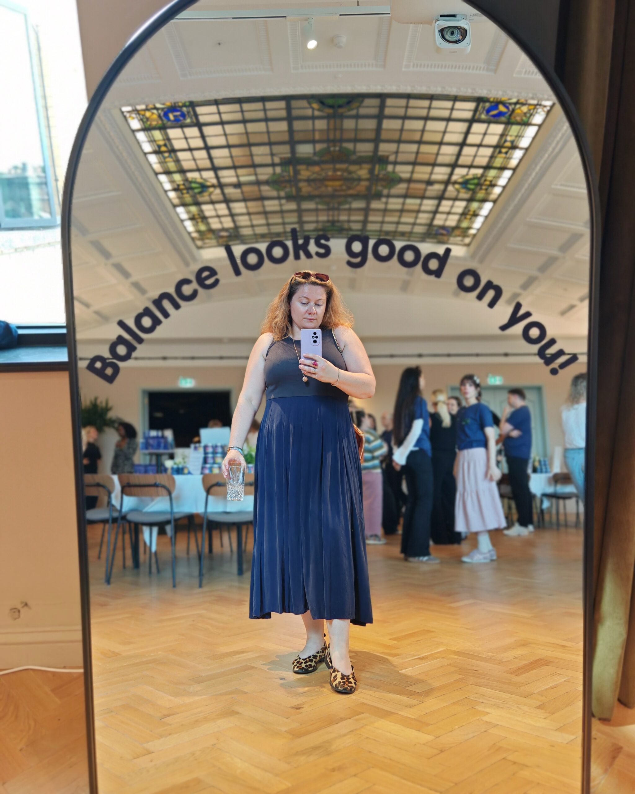White woman with a blue navy dress taking a selfie in a mirror 'Balance looks good on you!@ during a Bioglan Event in Clapham White woman with a blue navy dress taking a selfie in a mirror 'Balance looks good on you!@ during a Bioglan Event in Clapham