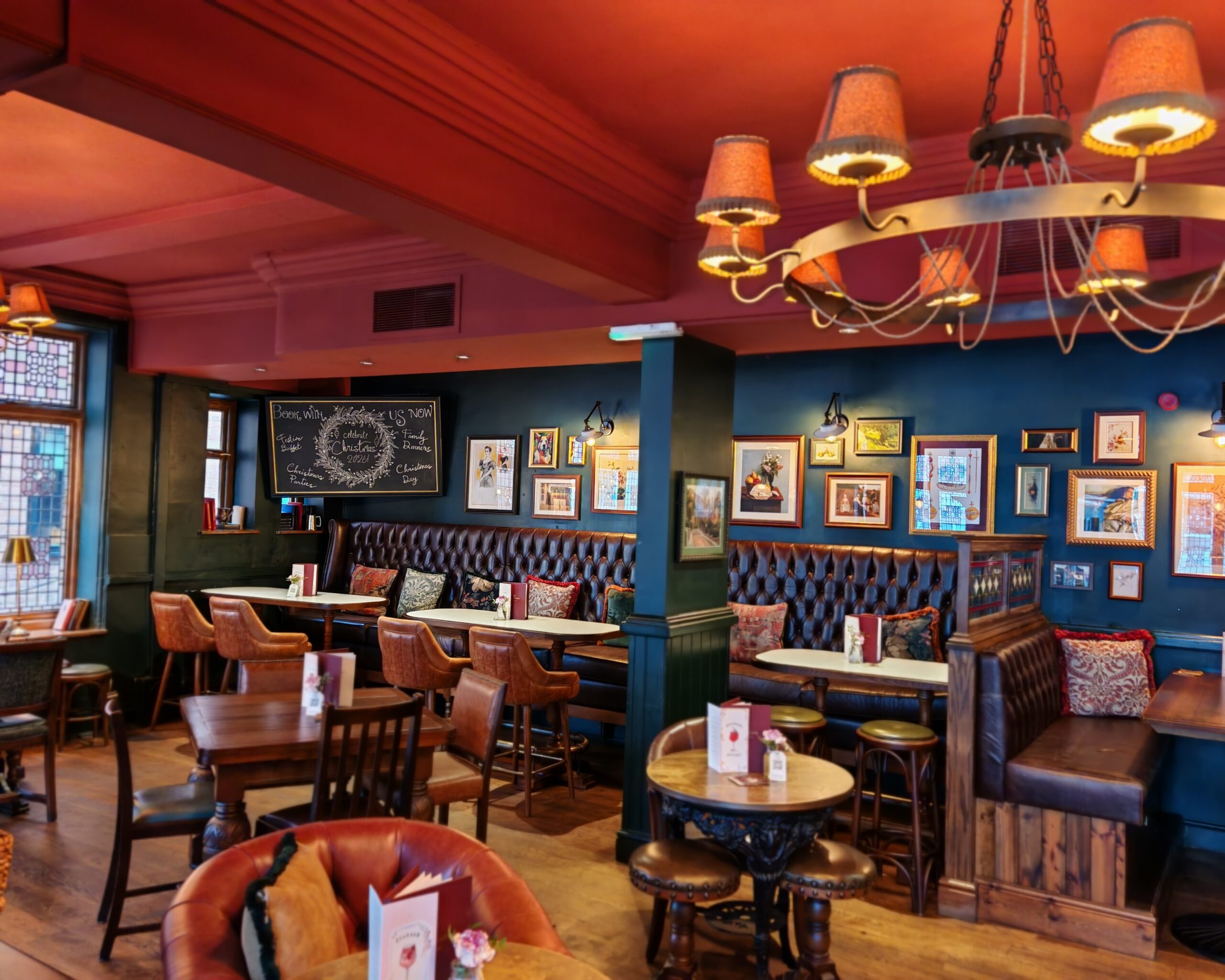 Interiors of the The Crown Pub in Chertsey with leather sofas around wooden tables and cosy lights on the ceiling Interiors of the The Crown Pub in Chertsey with leather sofas around wooden tables and cosy lights on the ceiling