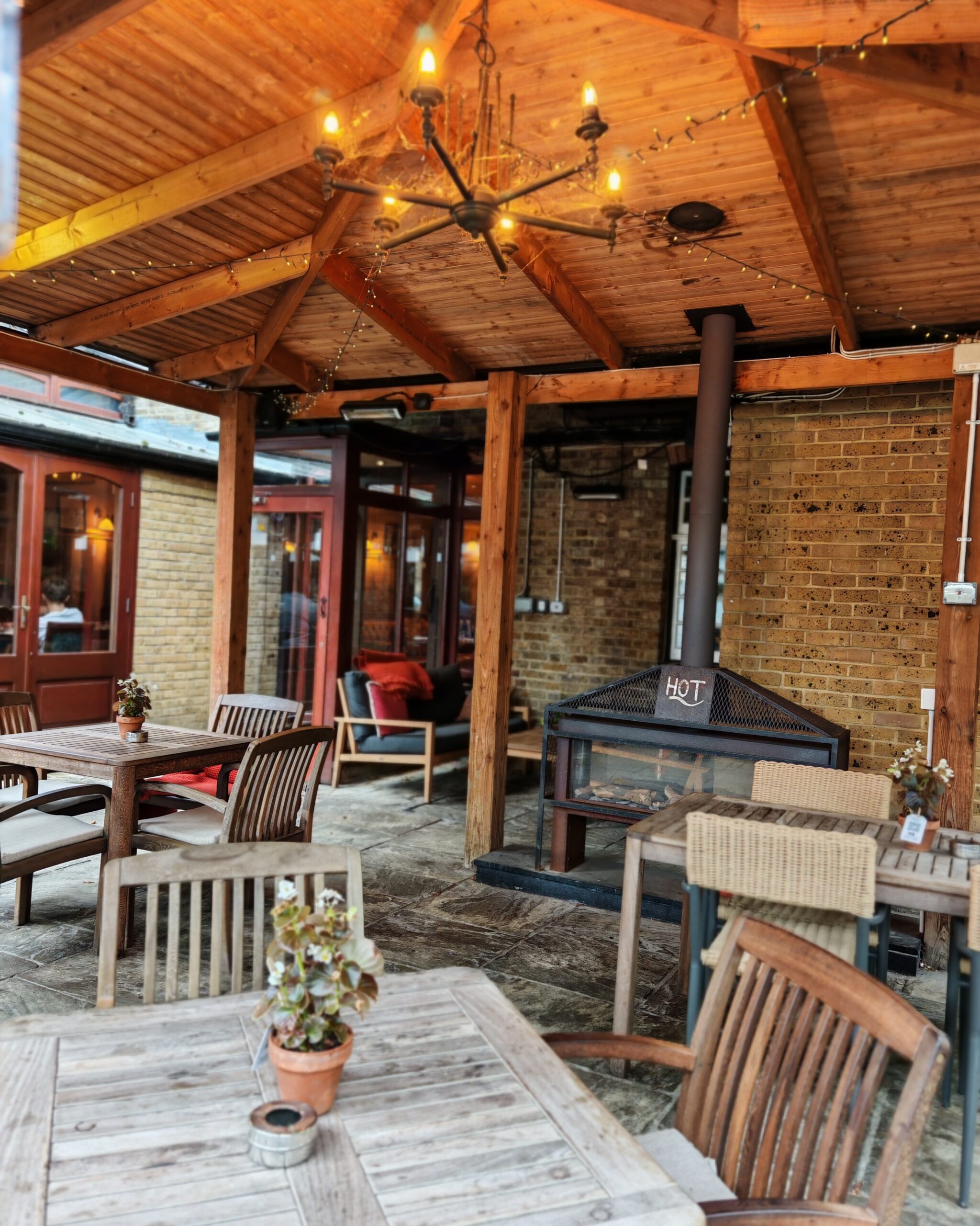 Beer garden at the back of the Crown in Chertsey, with a series of wooden tables and an outdoors oven to cook pizzas Beer garden at the back of the Crown in Chertsey, with a series of wooden tables and an outdoors oven to cook pizzas