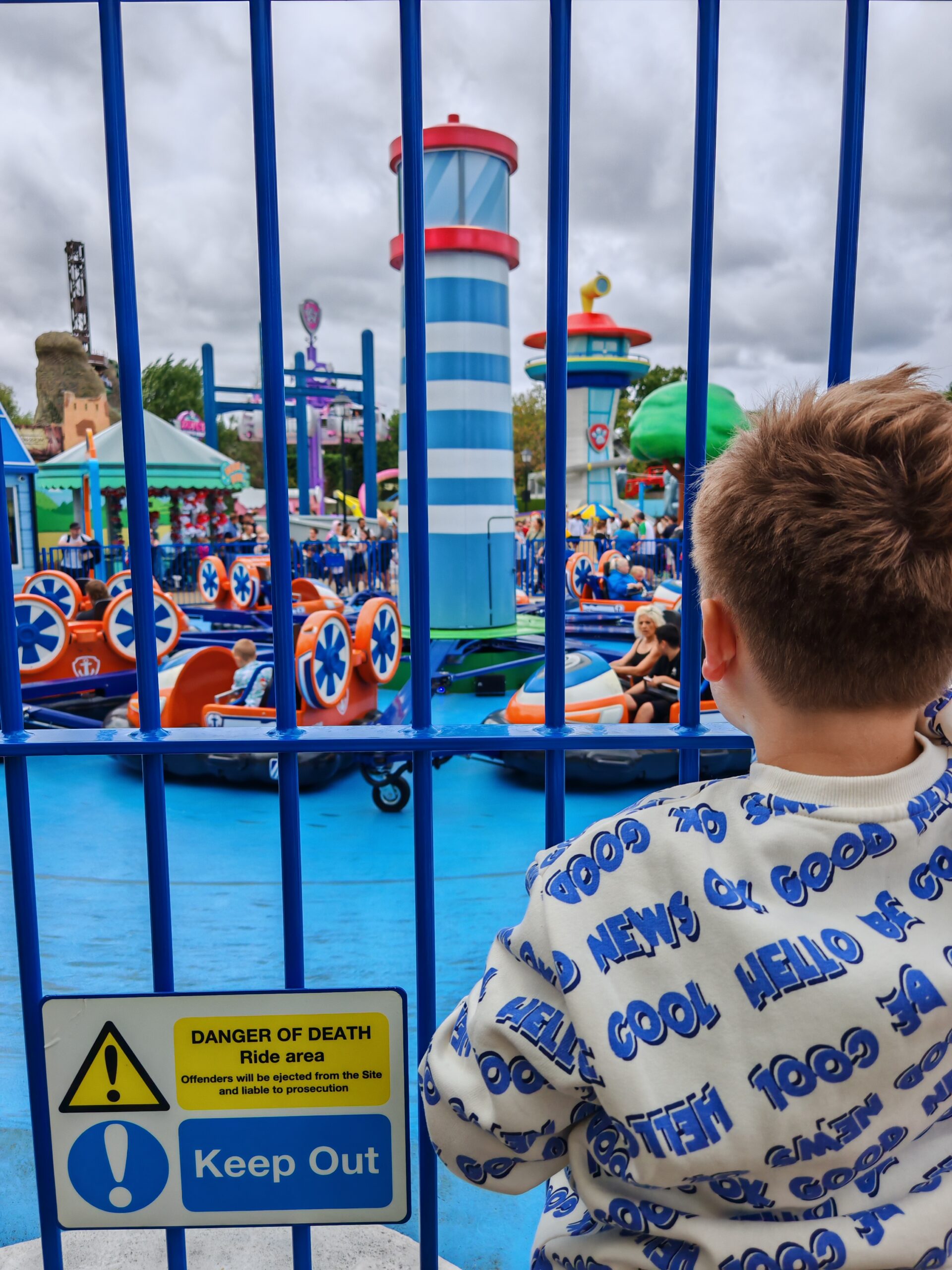 Boat ride at Chessington World of Adventures with a series of boat and a little boy watching others through the gate Boat ride at Chessington World of Adventures with a series of boat and a little boy watching others through the gate