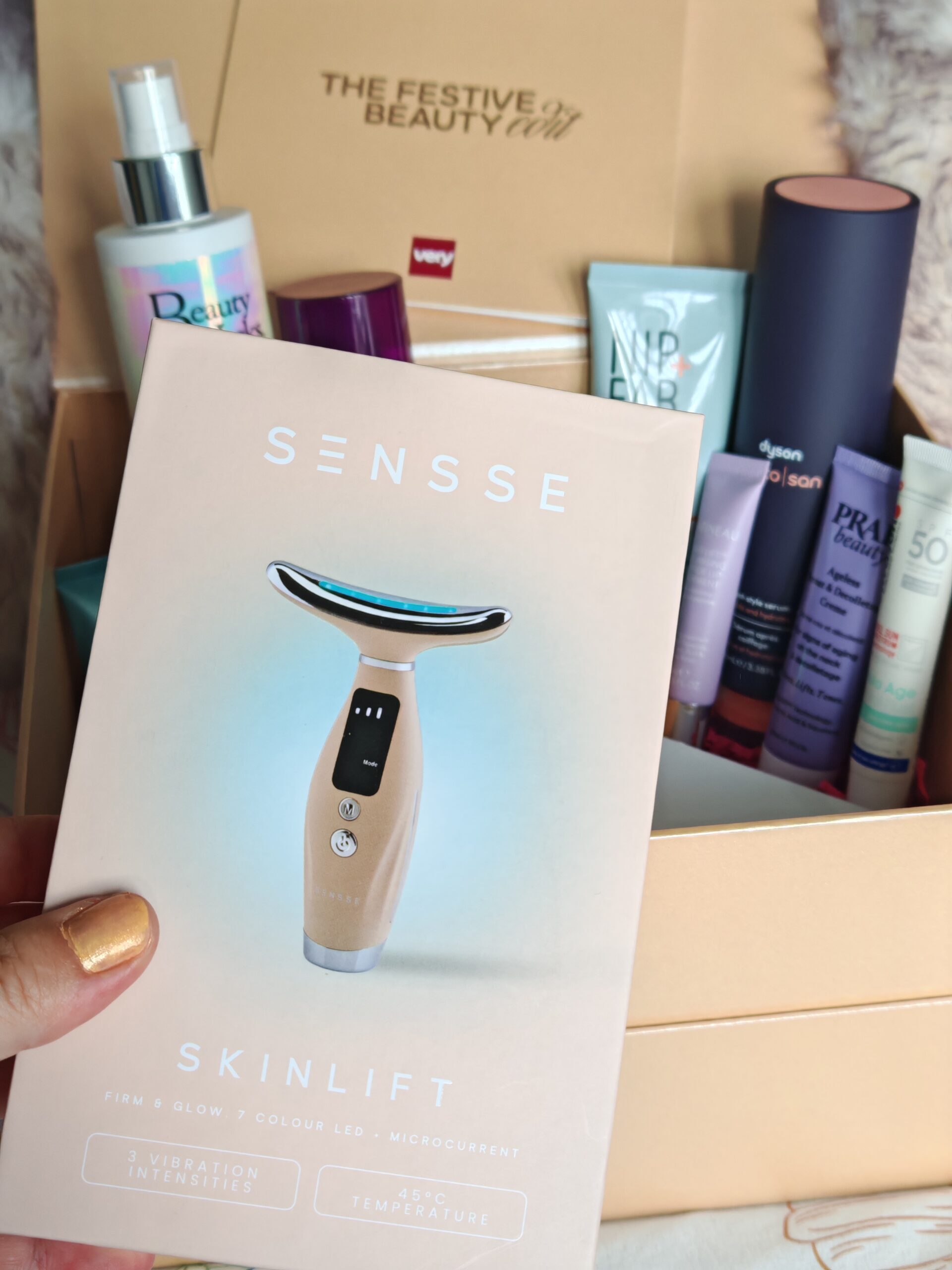 Very UK Festive Beauty Box with all the products in the background while zooming on Sense Skinlift sculpting face tool in the original box Very UK Festive Beauty Box with all the products in the background while zooming on Sense Skinlift sculpting face tool in the original box