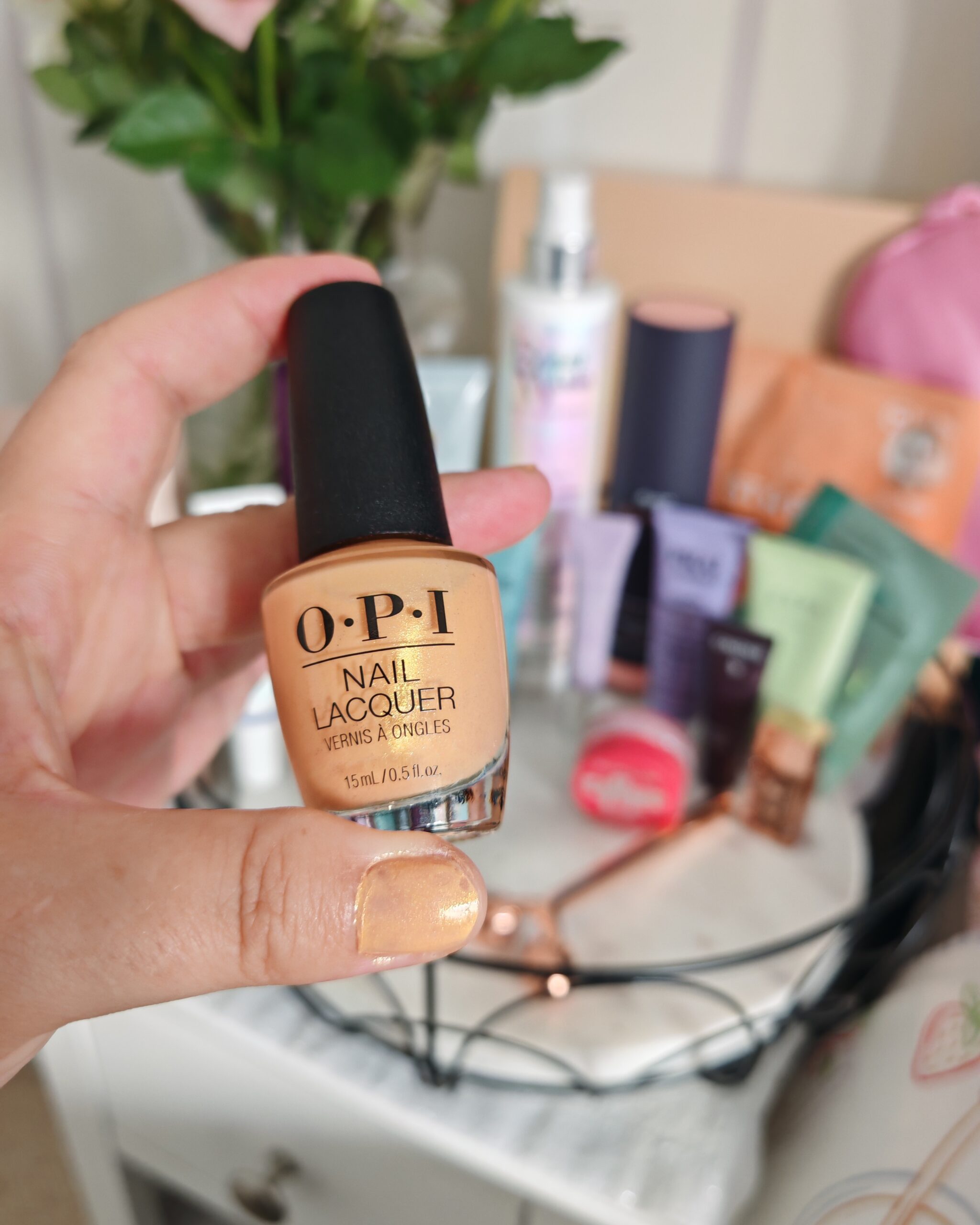Zoom of the opi nail lacquer with a selection of beauty products in the background, on a night table Zoom of the opi nail lacquer with a selection of beauty products in the background, on a night table